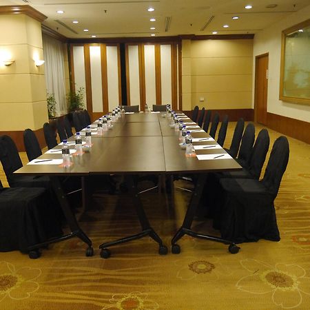 Seri Pacific Hotel Куала-Лумпур Экстерьер фото The photo shows a conference room setup featuring a long rectangular table surrounded by black upholstered chairs. The table appears to be organized for a meeting, with what looks like nameplates or notepads placed at each chair. The room has a forma