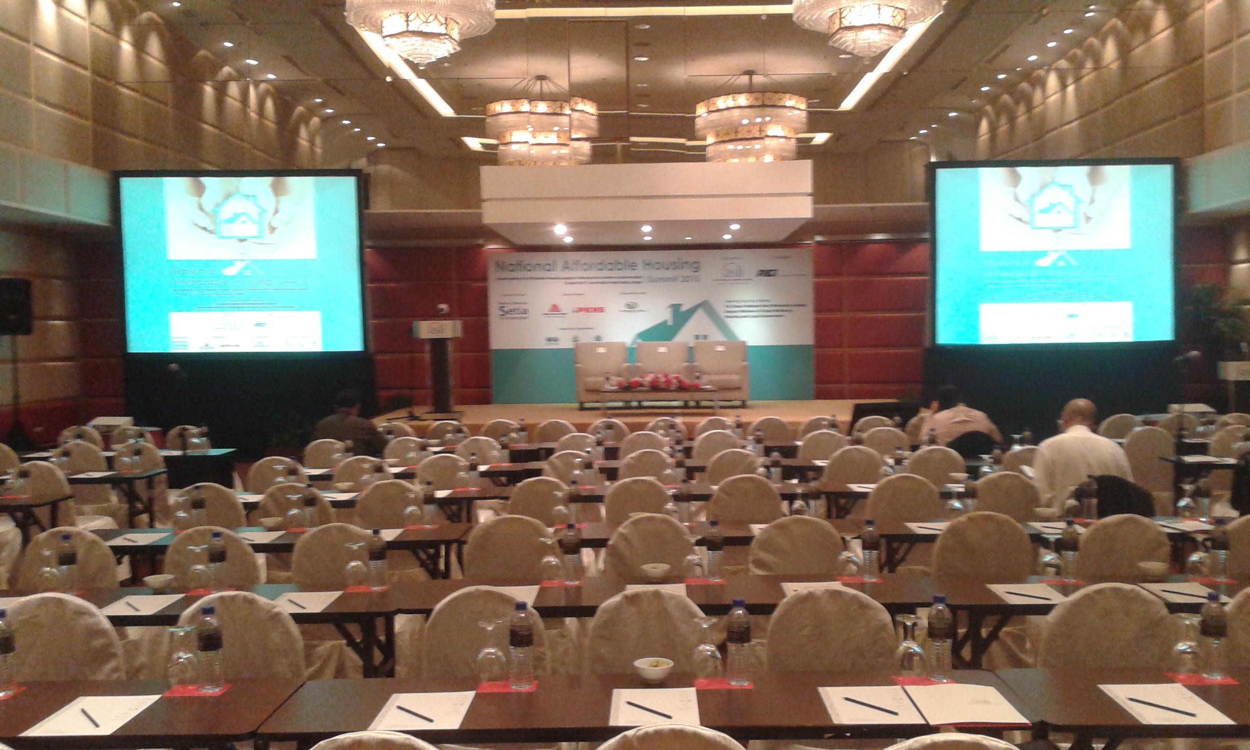 Seri Pacific Hotel Куала-Лумпур Экстерьер фото The photo shows a conference or seminar room set up for an event. There are many rows of tables and chairs arranged for participants, with each table equipped with a notepad and pen. In the front, there is a stage area with screens on either side dis