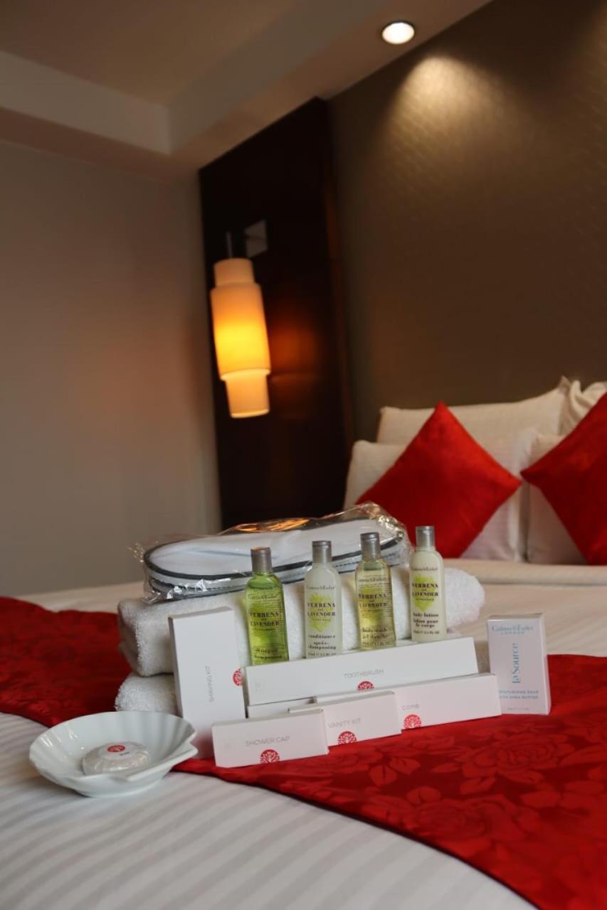 Seri Pacific Hotel Куала-Лумпур Экстерьер фото The photo shows a neatly arranged setup on a bed. In the foreground, there are several personal care products displayed, including bottles of shampoo and conditioner, as well as other toiletries, all presented on a white box. There are also two neatl