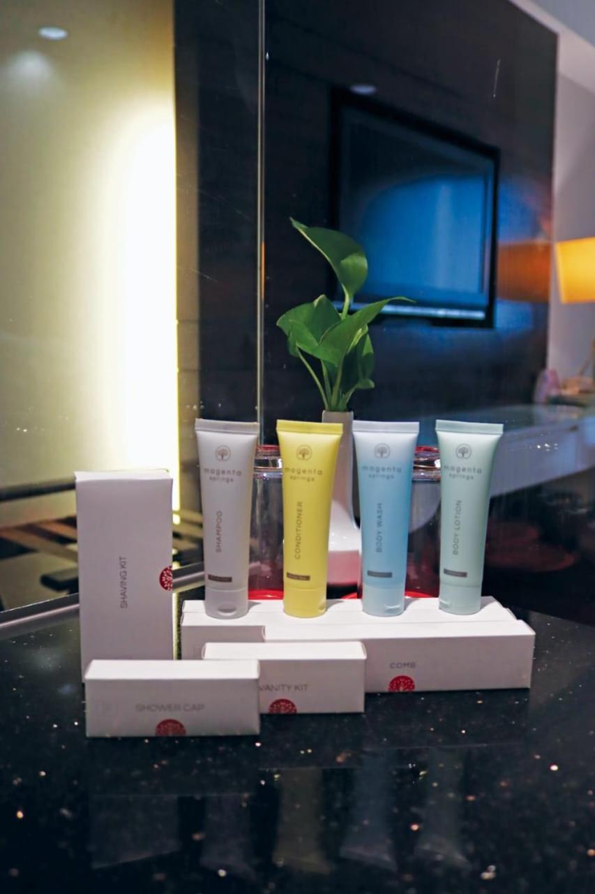 Seri Pacific Hotel Куала-Лумпур Экстерьер фото The photo shows a display of several small tubes of products, likely skincare or beauty items, arranged in a row on a shelf. The tubes are in different colors: one is white, another is yellow, and the other two are light green and blue. Behind the tu