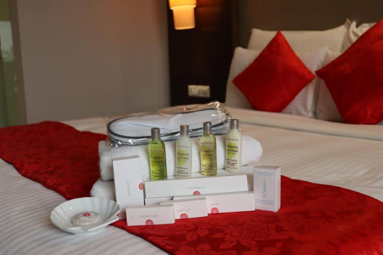 Seri Pacific Hotel Куала-Лумпур Экстерьер фото The photo shows a neatly arranged display on a bed. In the center, there is a set of four small bottles of toiletries, likely including various lotions or shampoos. These are accompanied by a white dish and two boxes, suggesting they may contain addi